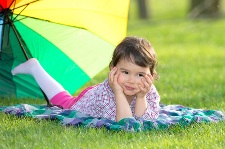 在公园的彩虹伞的小女孩