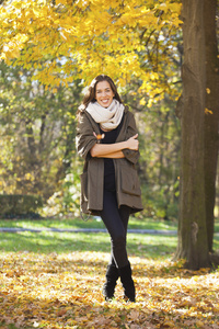 美丽而幸福的女人，在秋天的公园散步。秋天的季节
