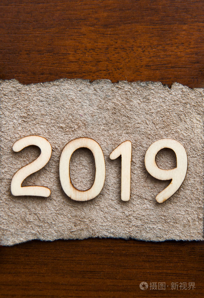 皮革招牌与日期2019 新年快乐。木桌背景