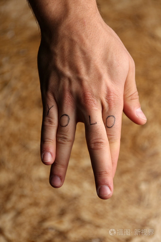 男性的手指上的纹身题字