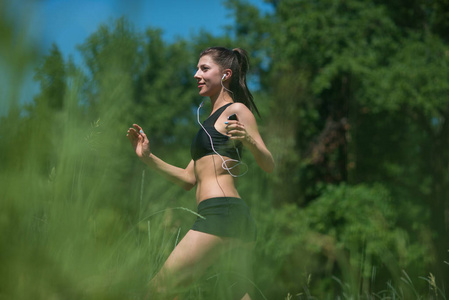 一个年轻女子在树林里奔跑。这个女孩从事体育运动。