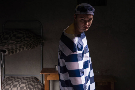 看犯人回头看生气的样子,一个小的黑暗监狱中的囚犯照片