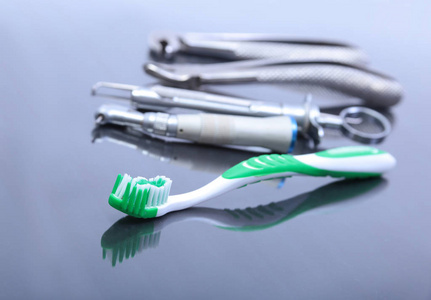 牙科保健牙刷与牙医工具上镜子背景