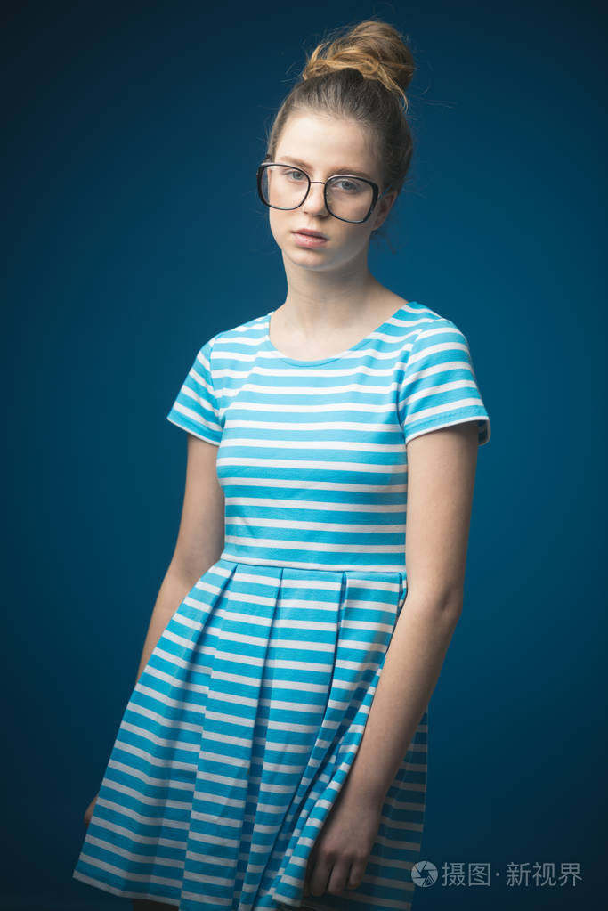 有大脑袋的美女在时尚礼服的眼镜漂亮的年轻女子的大脑和美丽.想大