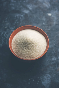 原粉面粉或 Rava 粉是硬质小麦的粗纯化小麦麦麸。在平原背景下作为堆或在碗或勺子服务。选择性聚焦