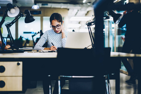 职业女性经理专注于在桌面上制定业务计划的工作任务, 认真的女办公室