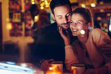 浪漫的年轻情侣晚上在酒吧约会照片