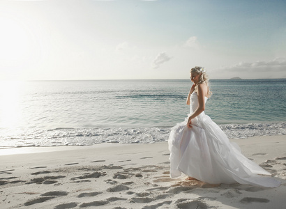 美丽可爱的新娘，日落海滩上散步