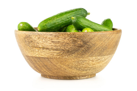 新鲜的绿色迷你黄瓜在一个木碗被隔绝在白色背景