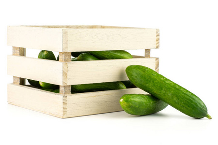 新鲜的绿色迷你黄瓜在一个木箱子被隔绝在白色背景