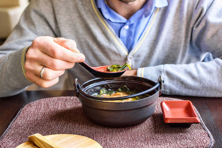 在传统的日本餐厅的人吃味噌汤图片