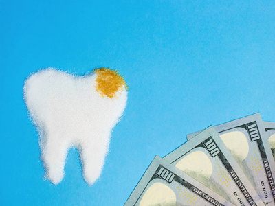 牙齿从白色和鲍恩糖与金钱在蓝色背景, 标志