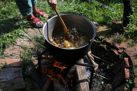 蒸煮炖牛肉或炖菜在户外的铸铁锅在大锅里炖肉的蔬菜.街