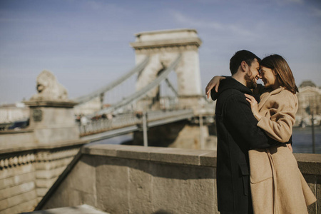 年轻快乐迷人情侣在爱拥抱匈牙利布达佩斯壮丽景色的背景
