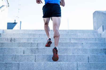 人跑在混凝土台阶在城市城市, 后方看法。健身与户外运动理念