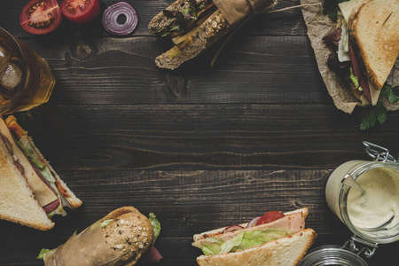 新鲜美味的三明治与副本空间木制的黑桌子上。顶视图