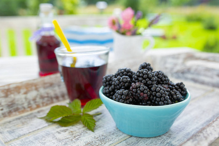 花园里木桌上的碗里的新鲜黑莓