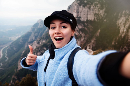 美丽的年轻女性游客在西班牙山区 josmonserrat 的自拍. 女人旅行者采取自拍在山旅行生活方式冒险概念户外活动假期