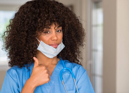 非洲裔美国妇女医疗专业愉快与大微笑做 ok 标志, 拇指用手指, 优秀标志