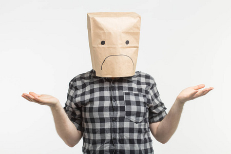 不满的人与悲伤的表情在他的头上的纸袋前白色背景照片