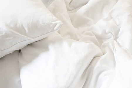 白色的枕头，在床上和皱凌乱条毯子，在卧室里