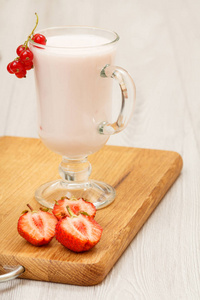 美味草莓酸奶薄荷叶玻璃和新鲜草莓在木制的切割板上