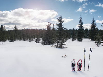 穿雪鞋在山上的软雪中行走。冬季体育活动概念