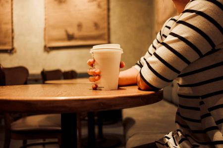 生活背景的年轻女子手持咖啡玻璃独自坐在餐厅与复制空间。形象为食物, 人, 饮料, 肖像概念