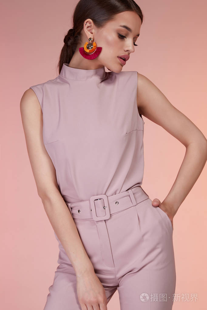 漂亮的性感优雅的女人时尚模特魅力姿势穿粉红色的裤子丝绸上衣西装