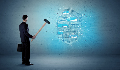 商人用巨大的锤子击打墙面砖照片