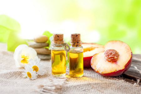 杏桃核仁油木桌上桃子的精油--一种疗愈芳香油照片