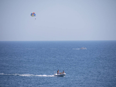 船上有一个人在降落伞和在海中间的机动船