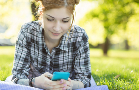在草地上使用智能手机的女人