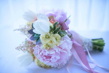 时尚, 柔和色调的婚礼花束的时尚肉质植物, 桃牡丹, 白色郁金香, 象牙玫瑰, 点缀着丝带, 侧面视图, 室内柔和的光和选择性的