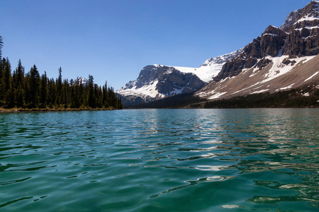 在一个充满阳光的夏日里, 在冰川湖上划独木舟。在加拿大艾伯塔省班夫国家公园的弓湖拍摄