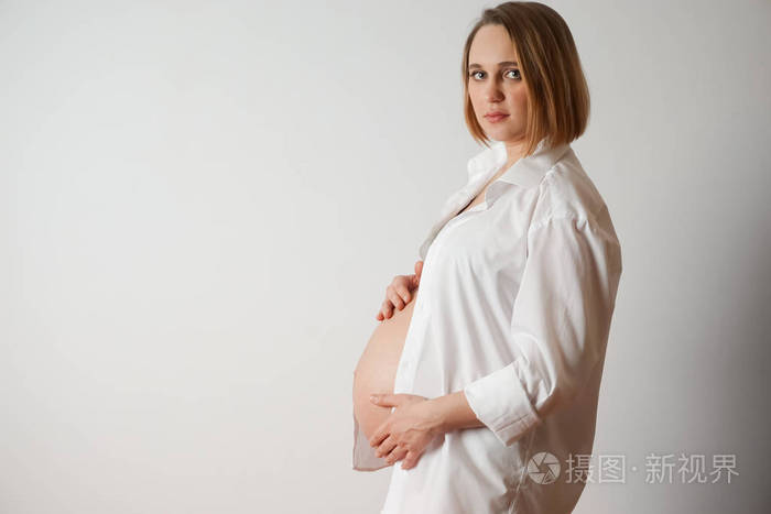 怀孕的女人轻背景上