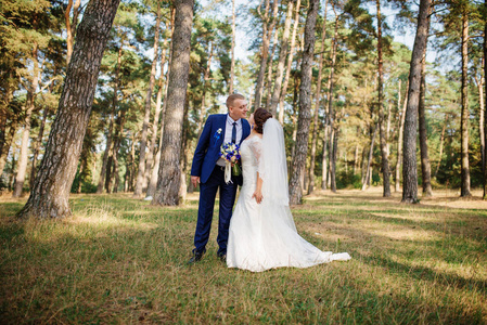 新娘和新郎在松树林中，自然可爱的婚礼夫妇