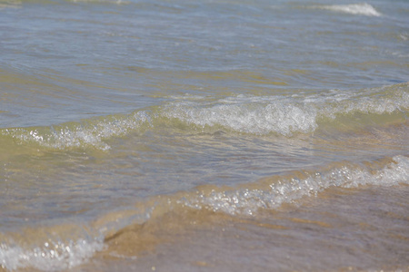 湖水面上带着小波浪在温暖阳光明媚的夏日里没有人。湖岸水背景近海岸线与太阳反射, 自然风景海景