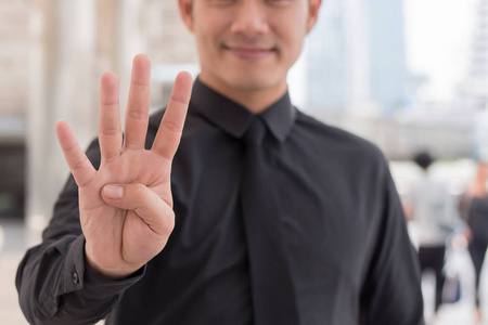 商人向上数 4 手指手势照片