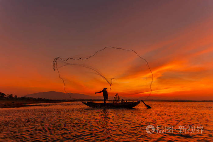 在日出的时候,缅甸抛网捕鱼茵莱湖的传统渔民的剪影