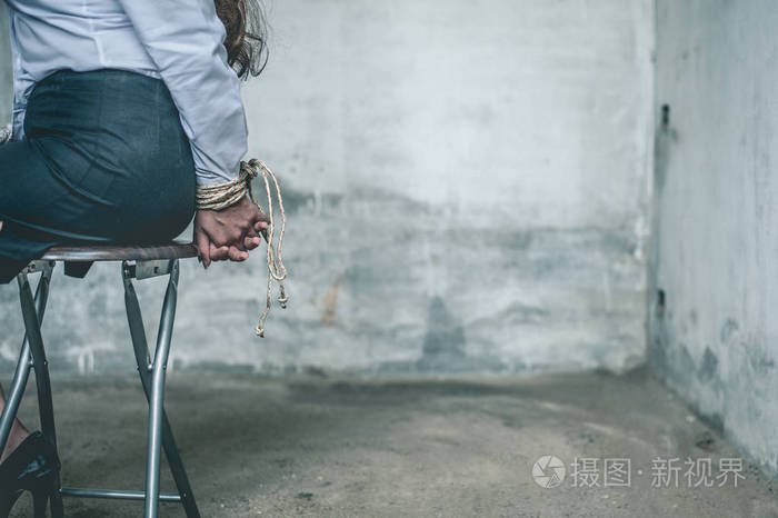 女人的手绑着妇女被戴上手铐坐在椅子上女人把手绑在椅子上犯罪概念