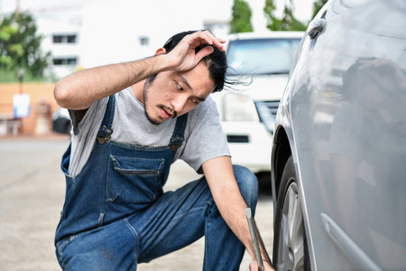 汽车维修理念。亚洲人正在路边修理汽车。亚洲人自信地修理汽车