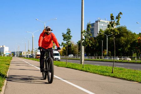 成年男子与背包骑自行车在城市街道。车