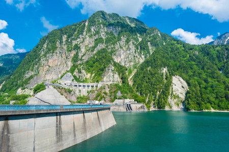 美丽的风景黑部水坝在轻快, 与五颜六色的湖畔山和清澈的湖水在蓝色晴朗的天空之下在立山黑部高山路线, 富山, 日本