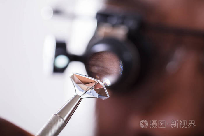 用放大镜看钻石的人的宏拍