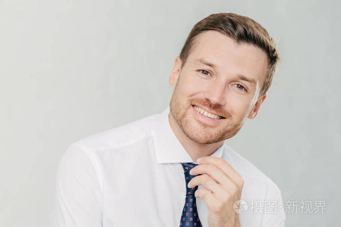 满意的男性工作者以积极的表情, 有着宽广的笑容, 与伴侣喜悦成功的