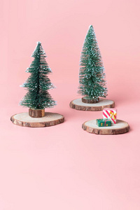 圣诞树上的木材日志切片与当前盒在粉彩粉红色工作室背景。带复制空间的节日庆典贺卡, 用于展示设计或内容