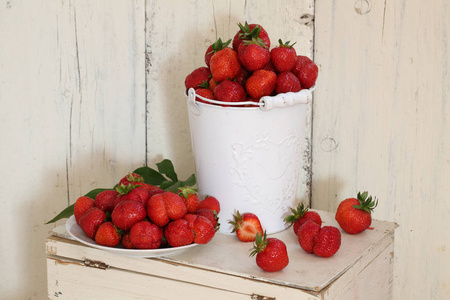 草莓。草莓在木制的桌子上一桶