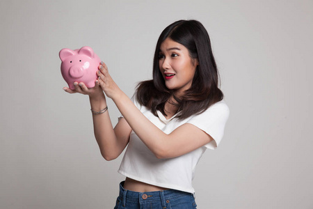 年轻的亚裔女子，和猪硬币银行