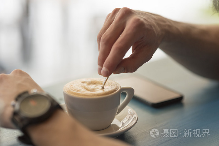 年轻人在咖啡厅喝咖啡的特写